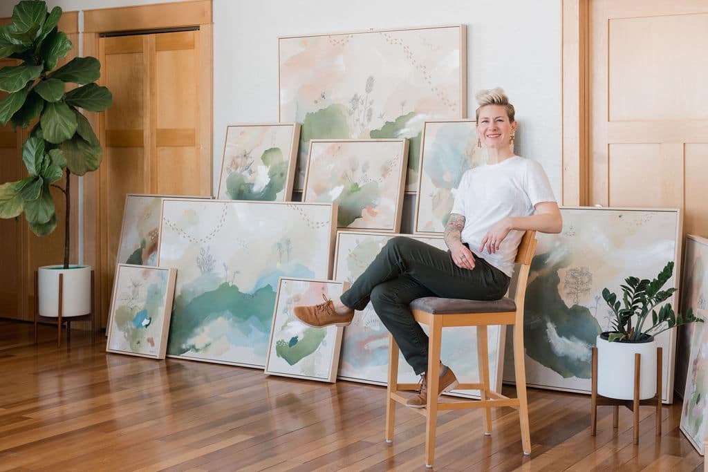 artist seated with art works