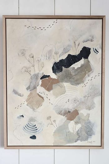 abstract painting hung on white boarded wall